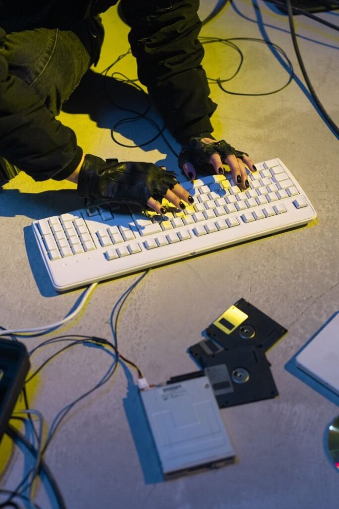 Cyberpunk-themed image showing a hacker typing on a keyboard with retro technology.